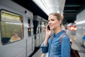 Woman making phone call at the underground platform, waiting Royalty Free Stock Photo