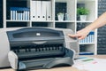 Woman making photocopy using copier in office