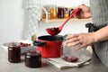 Woman making pickled cherries at table, closeup