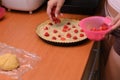 Woman making raspberry cake.