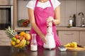 Woman making raspberry smoothie in a blender