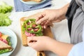 Woman making sandwich with green bell pepper and sausage at table, closeup Royalty Free Stock Photo