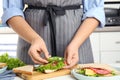 Woman making sandwich with green bell pepper and sausage at table, closeup Royalty Free Stock Photo