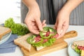 Woman making sandwich with bell pepper and sausage at white table, closeup Royalty Free Stock Photo