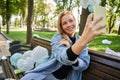 Woman making selfie at her smartphone with a lot of rubbish