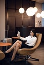 Woman making selfie by tablet in airport waiting room business lounge. Concept of modern technology, communication and Royalty Free Stock Photo