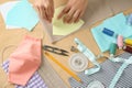 Woman making sewing template for cloth mask at table, closeup. Personal protective equipment during COVID-19 pandemic