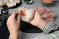 Woman making stuffed cabbage rolls at grey table, closeup