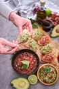 Woman making tasty salsa and guacamole bruschetta snacks at domestic kitchen