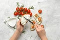 Woman making tasty sandwich with cream cheese on white background Royalty Free Stock Photo