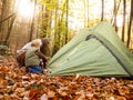 Woman making a tent with a little kid in a forest surrounded by leaves and greenery in the autumn Royalty Free Stock Photo