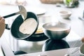 Woman making thin pancakes on frying pan in kitchen.