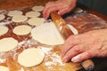 Woman making ukrainian dumplings or varenyky, roll out the dough of rolling pin