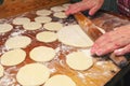 Woman making ukrainian dumplings or varenyky, roll out the dough of rolling pin