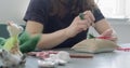 Woman making wool art doll toy at table close up. Female sitting and creating ooak doll at home. Needle Felted Handmade