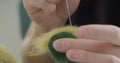 Woman making wool art doll toy at table close up. Female sitting and creating ooak doll at home. Needle Felted Handmade