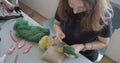 Woman making wool art doll toy at table. Female sitting and creating ooak doll at home. Needle Felted Handmade and