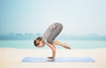 Woman making yoga in crane pose on mat Royalty Free Stock Photo