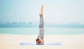 Woman making yoga in headstand pose on mat Royalty Free Stock Photo