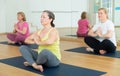 Woman making yoga meditation in half king of fish yoga pose - agni stambhasana