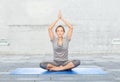 Woman making yoga meditation in lotus pose on mat Royalty Free Stock Photo