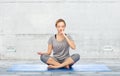 Woman making yoga meditation in lotus pose on mat Royalty Free Stock Photo