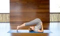 Woman making yoga in plow pose on mat