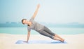 Woman making yoga in side plank pose on mat Royalty Free Stock Photo