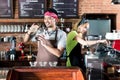 Woman and man in Asian cafe preparing coffee