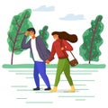 Woman and man in casual clothes walk in the park on the road along the tree alley in windy weather Royalty Free Stock Photo