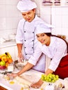 Woman and man in chef hat cooking dough