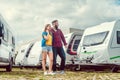 Woman and man choosing camper van to rent or buy