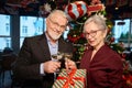 Woman and man clinking glasses of champagne hold gift box celebrating Christmas Royalty Free Stock Photo