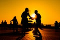 Woman and man couple silhouettes dancing against warm sunset orange sky