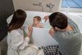 Woman and man crouched washing baby in bathroom