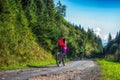 Woman and man cycling on mountain bikes on road in forest