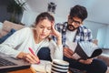 Woman and man doing paperwork together, paying taxes online