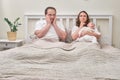 A woman and a man are in doubt after the birth of a newborn baby on the bed. Father and mother with a child boy, thoughtful Royalty Free Stock Photo
