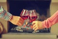 Woman and man drink wine on the background of the fireplace Royalty Free Stock Photo