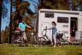 Woman with a man on electric bike resting at the campsite. Royalty Free Stock Photo