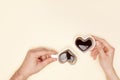 Woman and man hands hods heart shaped cup of coffee.