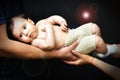 Woman and man hands holding a newborn. Mom, dad and baby. Close-up Royalty Free Stock Photo