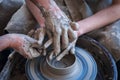 Woman and man hands. Potter at work. Creating dishes. Potter`s wheel. Dirty hands in the clay and the potter`s wheel Royalty Free Stock Photo