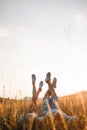 Woman and man having fun outdoors. Loving hipster couple are lying in the grass and lifting their legs in sneakers up in Royalty Free Stock Photo