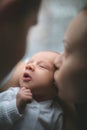 Woman and man holding on hands a newborn. Mom, dad and baby. Mother kissing her son. Happy family life. Man was born Royalty Free Stock Photo