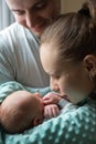 Woman and man holding on hands a newborn. Mom, dad and baby. Mother kissing her son. Happy family life. Man was born Royalty Free Stock Photo