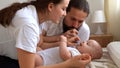 Woman And Man Holding Newborn. Mom, Dad And Baby On Bed. Close-up. Portrait of Young Smiling Family With Newborn On Royalty Free Stock Photo