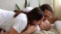 Woman And Man Holding Newborn. Mom, Dad And Baby On Bed. Close-up. Portrait of Young Smiling Family With Newborn On Royalty Free Stock Photo