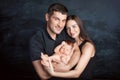 Woman and man holding a newborn. Mom, dad and baby. Close-up. Portrait of  smiling family with newborn on the hands. Happy family Royalty Free Stock Photo