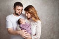 Woman and man holding a newborn. Mom, dad and baby.  Portrait of  smiling family with newborn on the hands. Happy family concept. Royalty Free Stock Photo